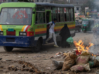 People are moving past burning garbage and plastic trash beside a busy road in Dhaka, Bangladesh, on May 23, 2024. Dhaka's air quality is be...