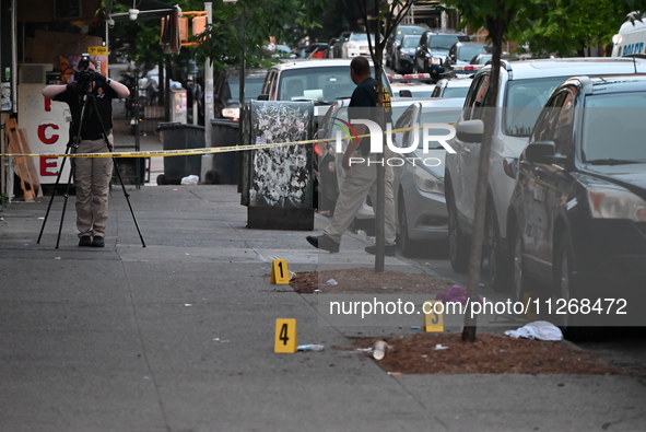 Evidence markers are at the crime scene as the crime scene unit is investigating the shooting. Three people are shot, and two people are dea...