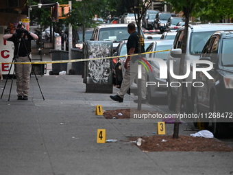 Evidence markers are at the crime scene as the crime scene unit is investigating the shooting. Three people are shot, and two people are dea...