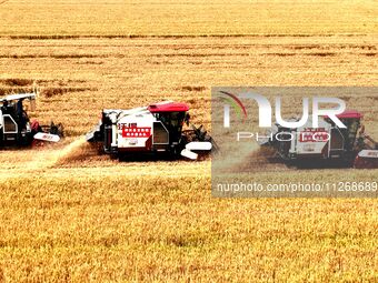 Harvesters are harvesting wheat in a field in Suqian, Jiangsu province, China, on May 24, 2024. (