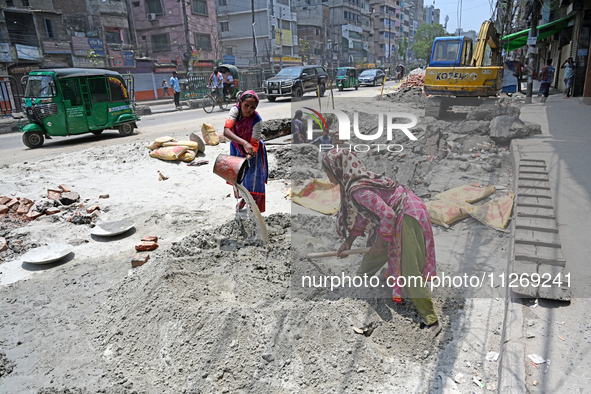 Women daily laborers work at a road construction site in Dhaka, Bangladesh, on May 24, 2024. 