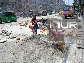 Women daily laborers work at a road construction site in Dhaka, Bangladesh, on May 24, 2024. (