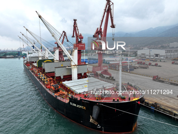 Cargo ships are parking at a berth to load wind power equipment for export at the terminal in Lianyungang, China, on May 25, 2024. 