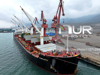 Cargo ships are parking at a berth to load wind power equipment for export at the terminal in Lianyungang, China, on May 25, 2024. (