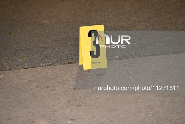 Crime scene investigators are marking shell casings and other evidence at the scene of a shooting where one person is killed and one person...