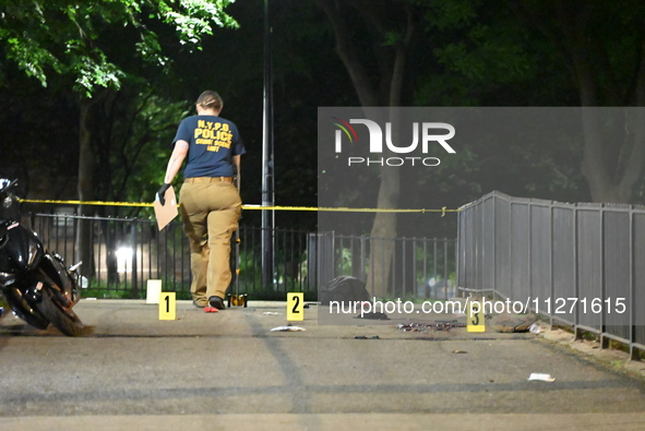 Crime scene investigators are marking shell casings and other evidence at the scene of a shooting where one person is killed and one person...