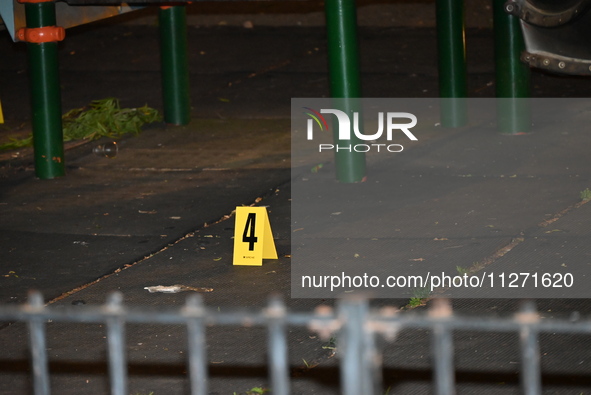 Crime scene investigators are marking shell casings and other evidence at the scene of a shooting where one person is killed and one person...