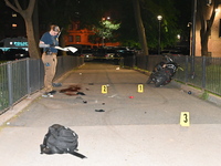 Crime scene investigators are marking shell casings and other evidence at the scene of a shooting where one person is killed and one person...