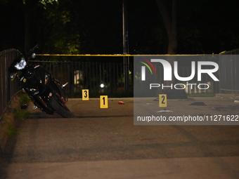 Crime scene investigators are marking shell casings and other evidence at the scene of a shooting where one person is killed and one person...