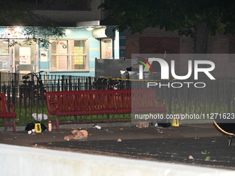 Crime scene investigators are marking shell casings and other evidence at the scene of a shooting where one person is killed and one person...