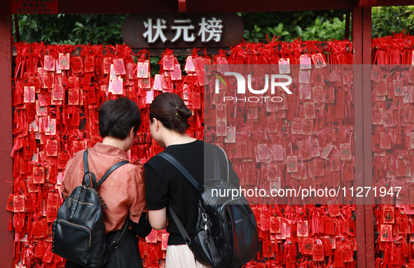 Parents are praying for a good score for their children who are taking the National college entrance examination (GAOKAO) at the Confucius T...