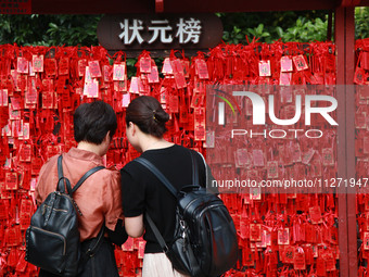 Parents are praying for a good score for their children who are taking the National college entrance examination (GAOKAO) at the Confucius T...