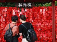 Parents are praying for a good score for their children who are taking the National college entrance examination (GAOKAO) at the Confucius T...