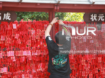 Parents are praying for a good score for their children who are taking the National college entrance examination (GAOKAO) at the Confucius T...