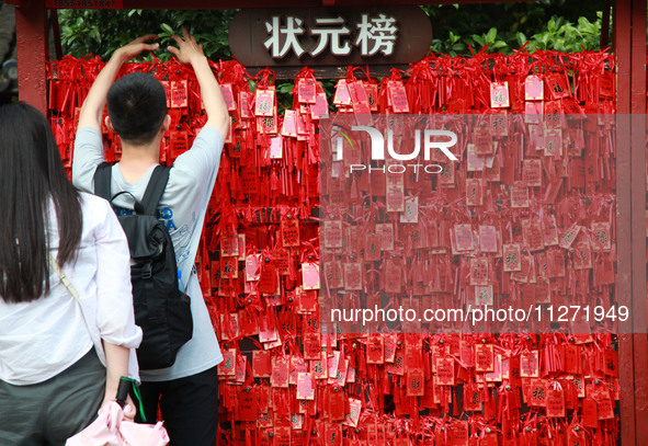 Parents are praying for a good score for their children who are taking the National college entrance examination (GAOKAO) at the Confucius T...