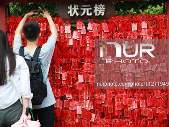 Parents are praying for a good score for their children who are taking the National college entrance examination (GAOKAO) at the Confucius T...