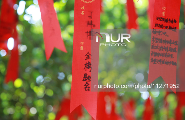 Parents are praying for a good score for their children who are taking the National college entrance examination (GAOKAO) at the Confucius T...