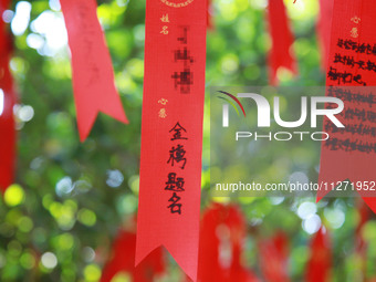 Parents are praying for a good score for their children who are taking the National college entrance examination (GAOKAO) at the Confucius T...