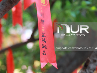 Parents are praying for a good score for their children who are taking the National college entrance examination (GAOKAO) at the Confucius T...