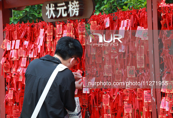 Parents are praying for a good score for their children who are taking the National college entrance examination (GAOKAO) at the Confucius T...