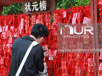 Parents are praying for a good score for their children who are taking the National college entrance examination (GAOKAO) at the Confucius T...