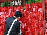 Parents are praying for a good score for their children who are taking the National college entrance examination (GAOKAO) at the Confucius T...