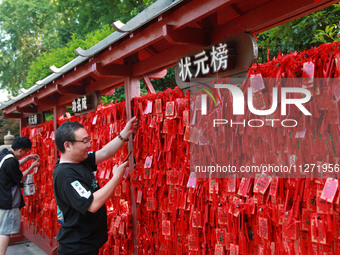 Parents are praying for a good score for their children who are taking the National college entrance examination (GAOKAO) at the Confucius T...