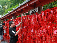 Parents are praying for a good score for their children who are taking the National college entrance examination (GAOKAO) at the Confucius T...