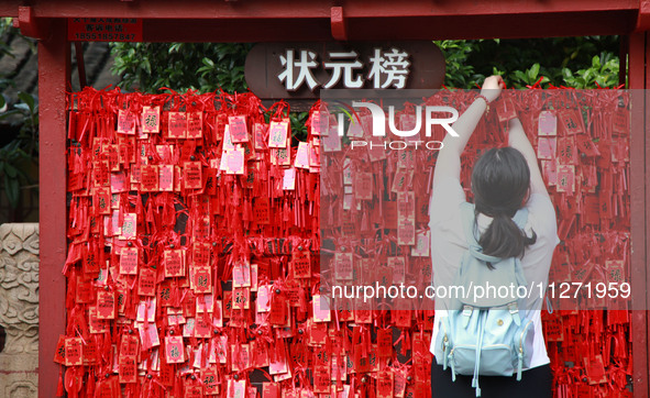 Parents are praying for a good score for their children who are taking the National college entrance examination (GAOKAO) at the Confucius T...