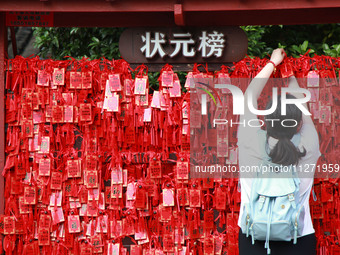 Parents are praying for a good score for their children who are taking the National college entrance examination (GAOKAO) at the Confucius T...