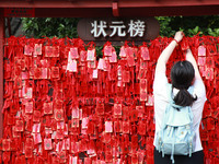 Parents are praying for a good score for their children who are taking the National college entrance examination (GAOKAO) at the Confucius T...