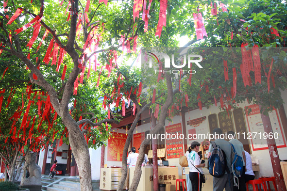 Parents are praying for a good score for their children who are taking the National college entrance examination (GAOKAO) at the Confucius T...