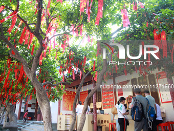 Parents are praying for a good score for their children who are taking the National college entrance examination (GAOKAO) at the Confucius T...