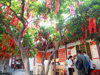 Parents are praying for a good score for their children who are taking the National college entrance examination (GAOKAO) at the Confucius T...