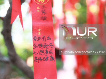 Parents are praying for a good score for their children who are taking the National college entrance examination (GAOKAO) at the Confucius T...