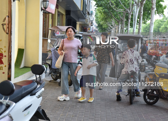 Citizens are walking on a street in Fuyang, Anhui province, China, on May 25, 2024. The World Health Organization (WHO) is releasing its ann...