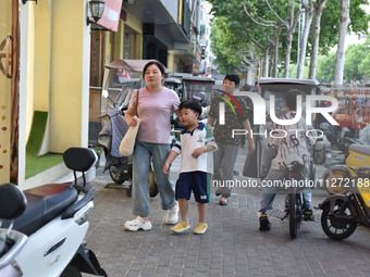 Citizens are walking on a street in Fuyang, Anhui province, China, on May 25, 2024. The World Health Organization (WHO) is releasing its ann...