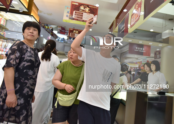 People are shopping at a mall in Fuyang, China, on May 25, 2024. The World Health Organization (WHO) is releasing its annual statistics on T...