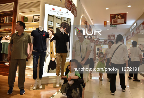 People are shopping at a mall in Fuyang, China, on May 25, 2024. The World Health Organization (WHO) is releasing its annual statistics on T...