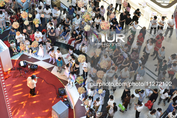 People are watching a performance at a shopping mall in Fuyang, China, on May 25, 2024. The World Health Organization (WHO) is releasing its...