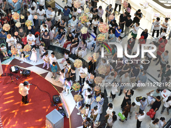 People are watching a performance at a shopping mall in Fuyang, China, on May 25, 2024. The World Health Organization (WHO) is releasing its...