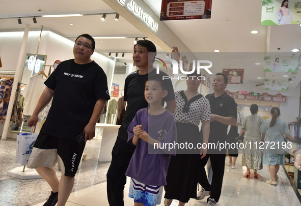 People are shopping at a mall in Fuyang, China, on May 25, 2024. The World Health Organization (WHO) is releasing its annual statistics on T...