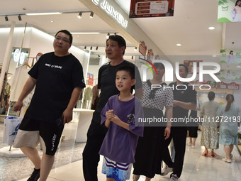 People are shopping at a mall in Fuyang, China, on May 25, 2024. The World Health Organization (WHO) is releasing its annual statistics on T...