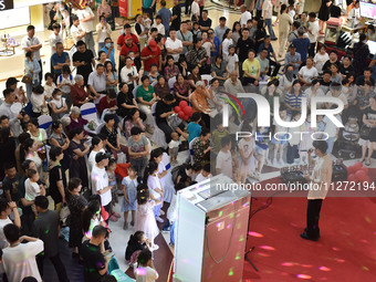 People are watching a performance at a shopping mall in Fuyang, China, on May 25, 2024. The World Health Organization (WHO) is releasing its...