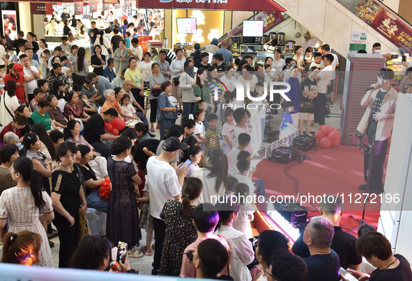 People are watching a performance at a shopping mall in Fuyang, China, on May 25, 2024. The World Health Organization (WHO) is releasing its...