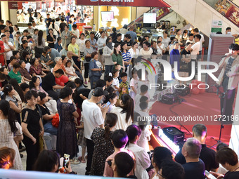 People are watching a performance at a shopping mall in Fuyang, China, on May 25, 2024. The World Health Organization (WHO) is releasing its...