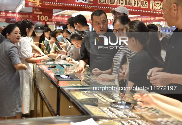 People are shopping for gold jewelry at a mall in Fuyang, China, on May 25, 2024. The World Health Organization (WHO) is releasing its annua...