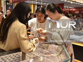 People are shopping for gold jewelry at a mall in Fuyang, China, on May 25, 2024. The World Health Organization (WHO) is releasing its annua...