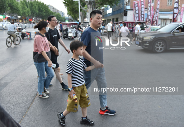 Citizens are walking on a street in Fuyang, Anhui province, China, on May 25, 2024. The World Health Organization (WHO) is releasing its ann...