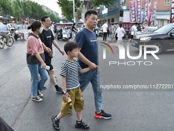 Citizens are walking on a street in Fuyang, Anhui province, China, on May 25, 2024. The World Health Organization (WHO) is releasing its ann...